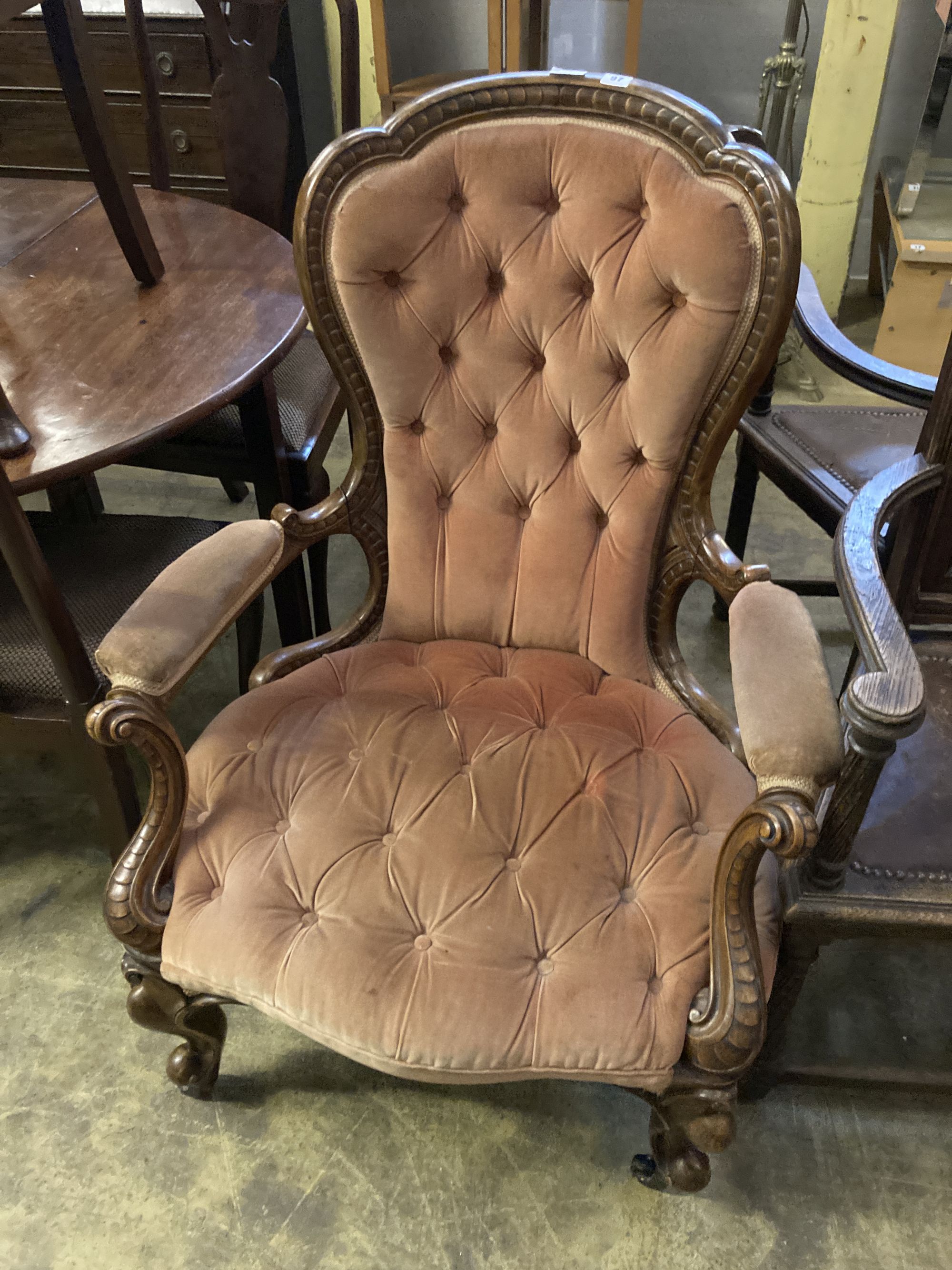 A Victorian carved walnut upholstered spoon back armchair, width 75cm, depth 70cm, height 102cm